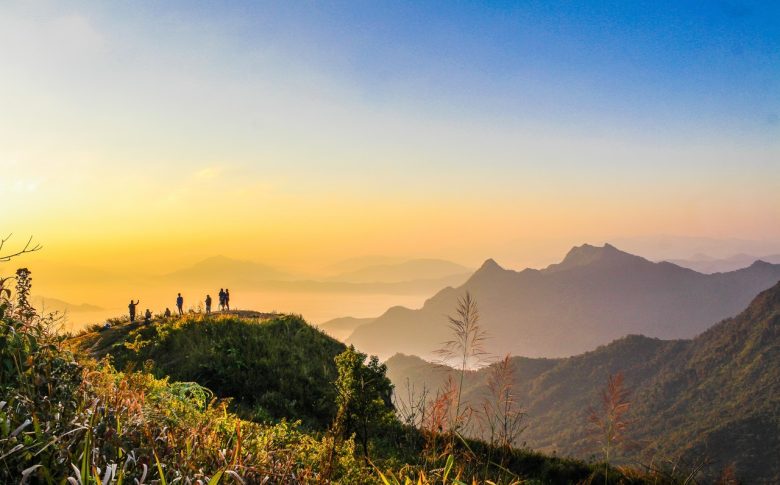 photo-of-people-standing-on-top-of-mountain-near-grasses-733162.jpg